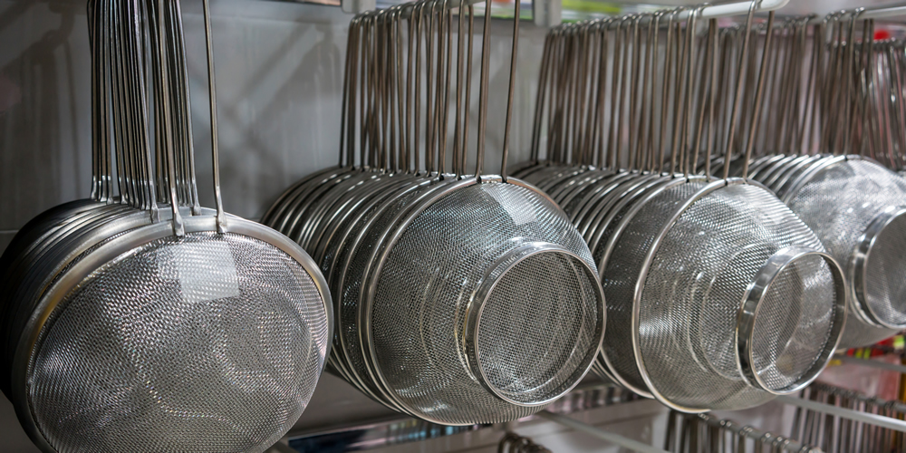 Siebe hängen an der Wand.